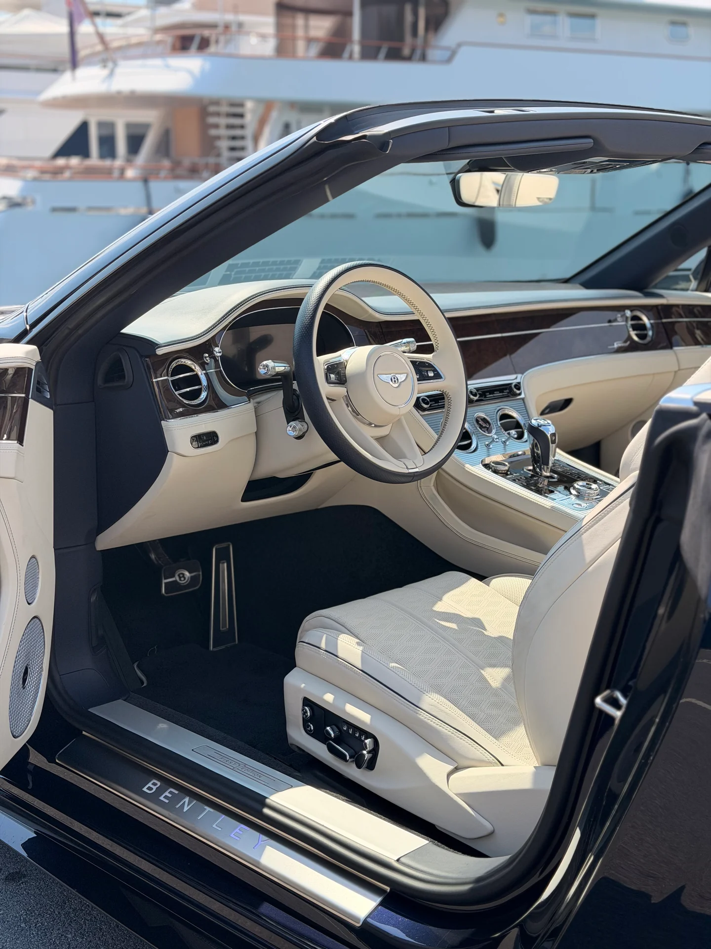 Abitacolo chiaro della Bentley Continental GTC con volante, plancia e sedile anteriore