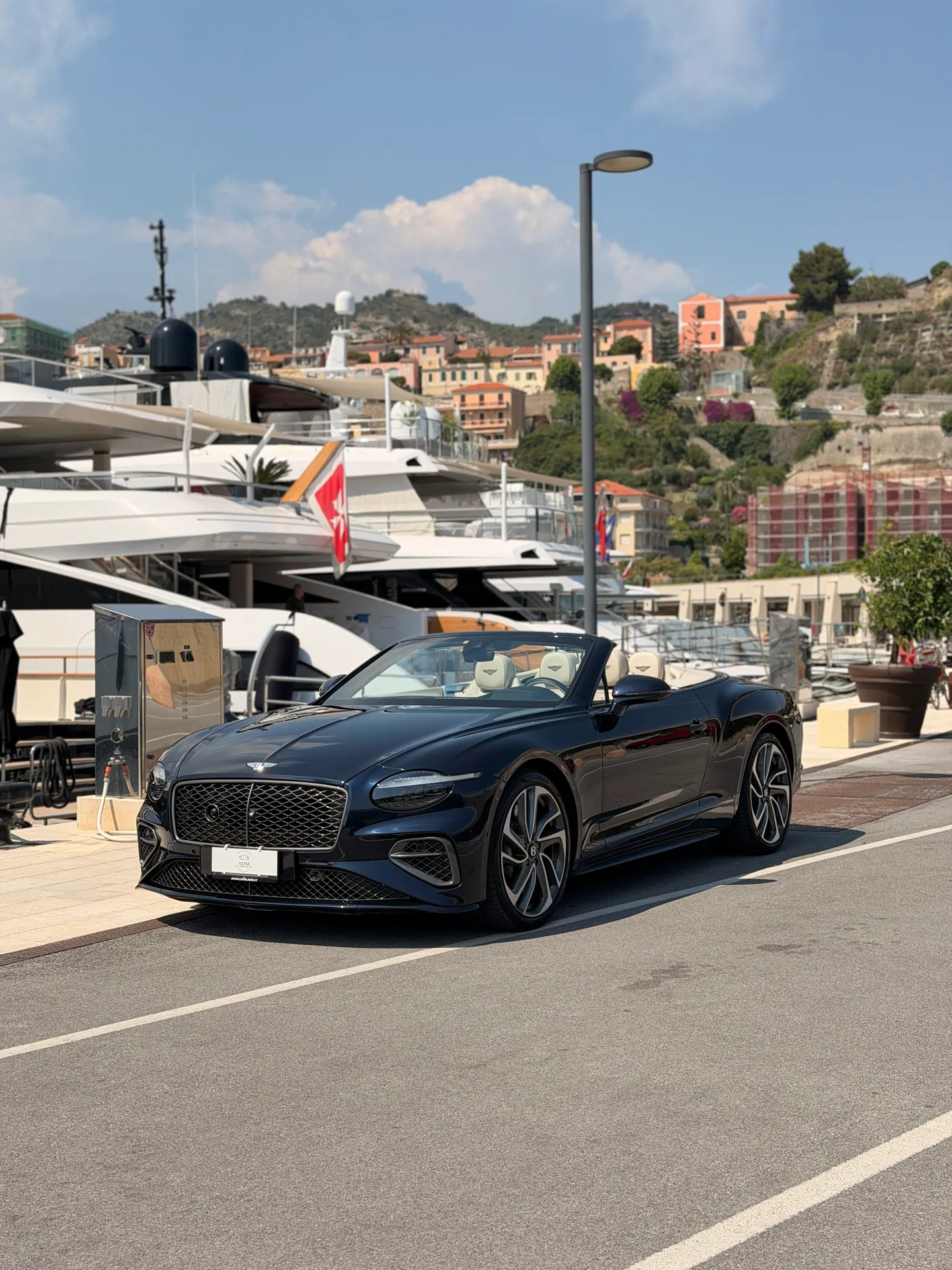 Bentley Continental GTC nera a tetto aperto, vista di tre quarti anteriore in porto