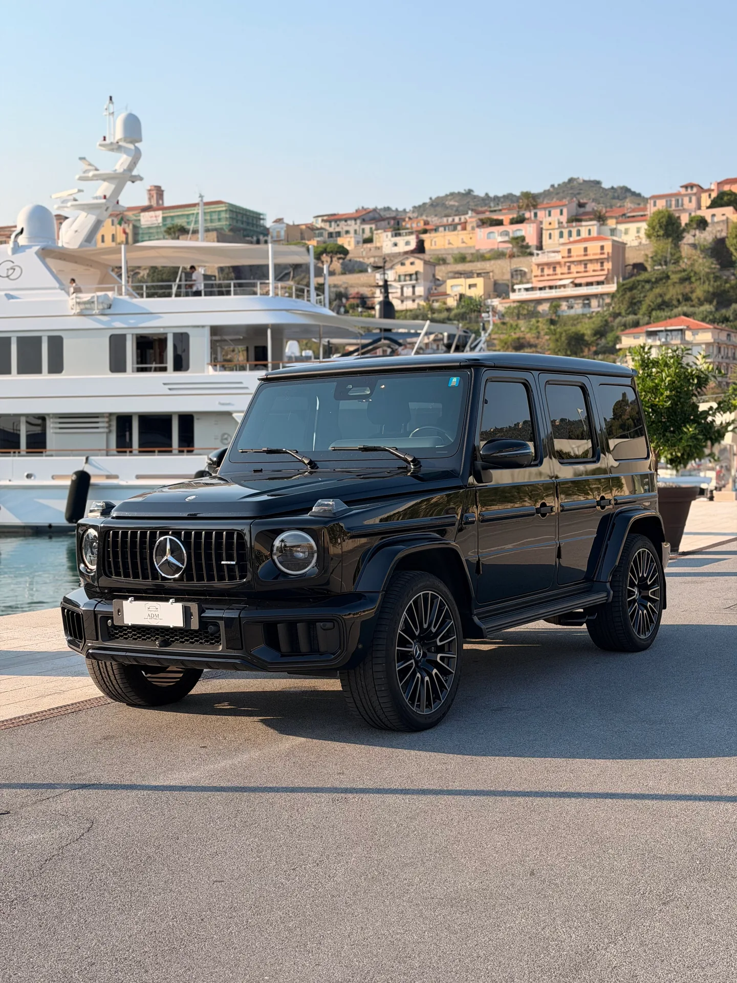 Mercedes-AMG G63 nera, vista di tre quarti anteriore davanti agli yacht