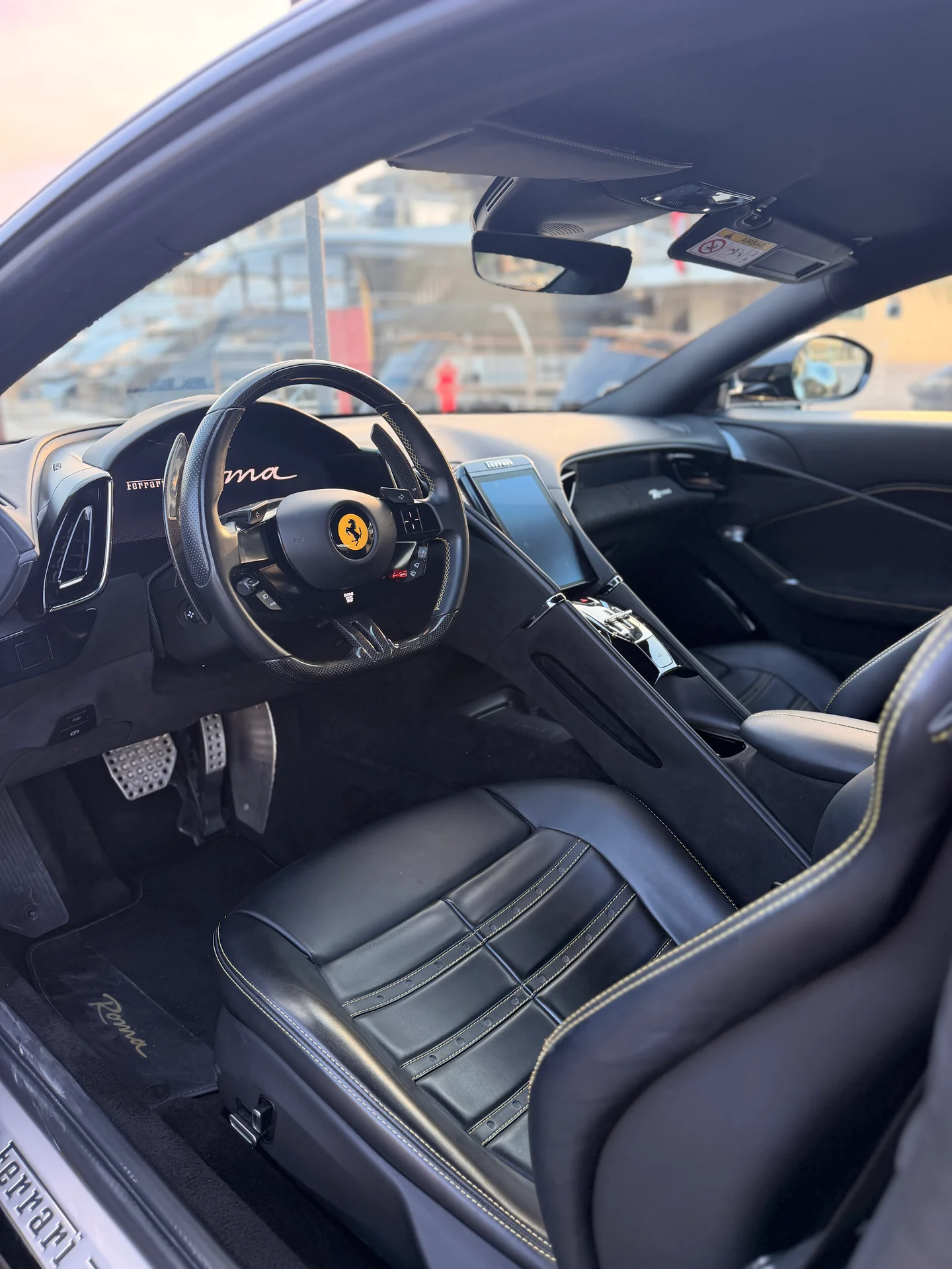 Abitacolo della Ferrari Roma Coupé con sedile scuro, volante e console centrale