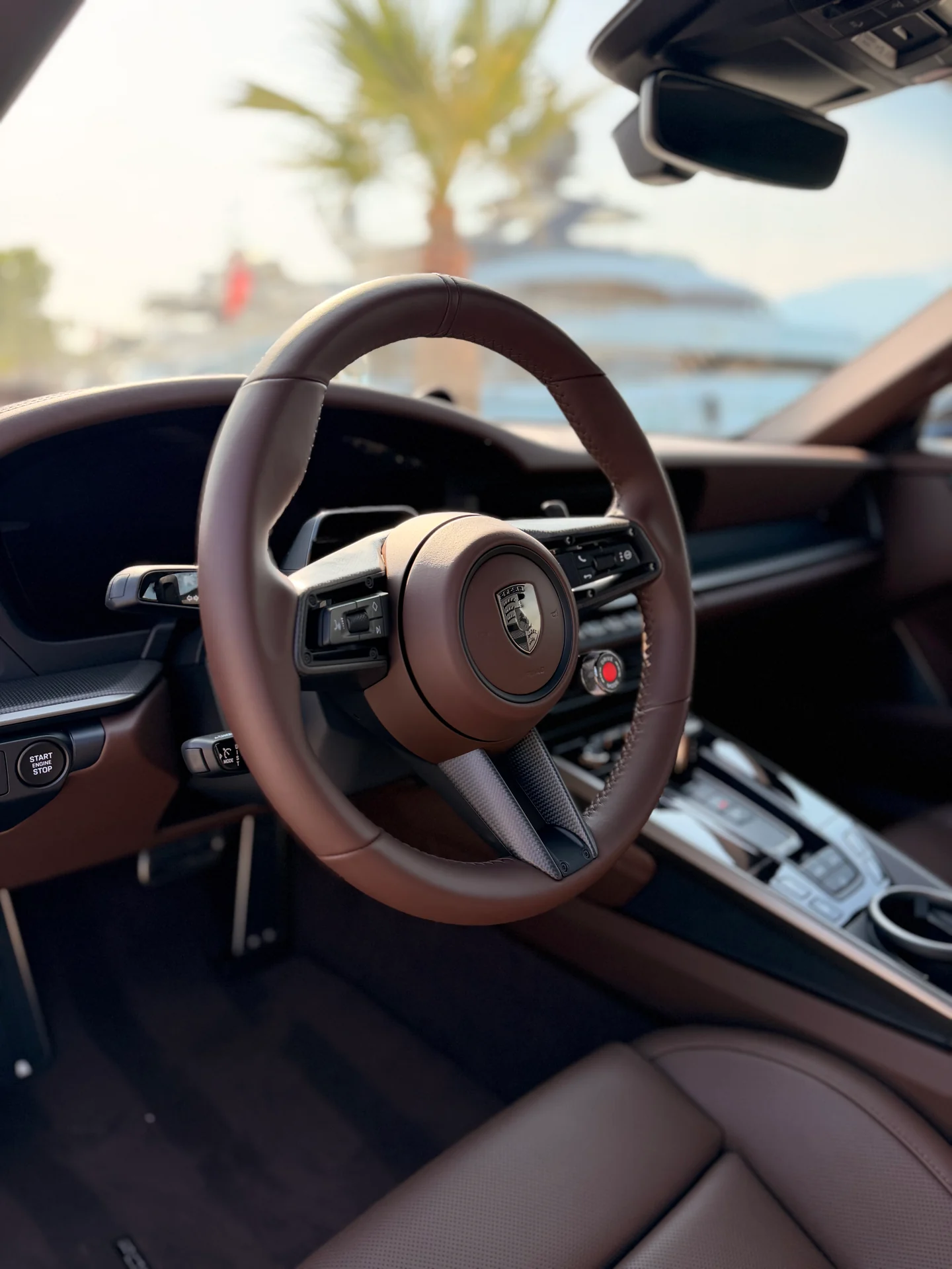 Abitacolo marrone della Porsche 911 Turbo S con volante, sedile anteriore e console centrale.