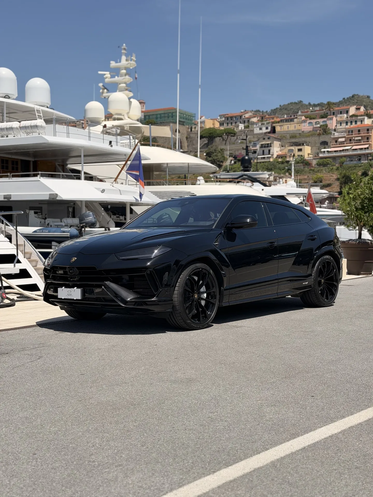 Lamborghini Urus nera, vista di tre quarti anteriore accanto agli yacht