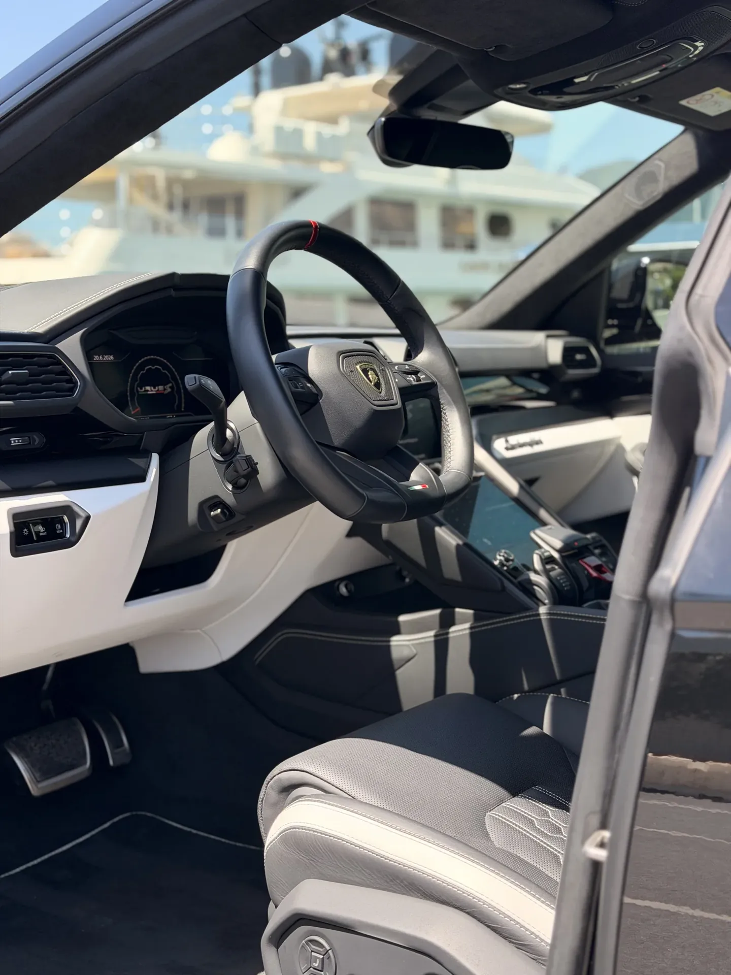 Volante e console della Lamborghini Urus con superfici chiare e scure nell’abitacolo